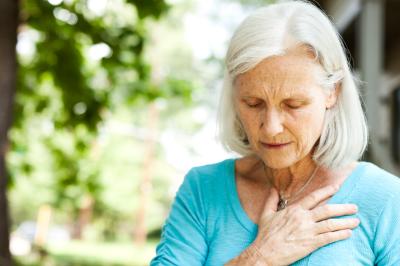 Frau fasst sich wegen Herzrhythmusstörungen an Brust